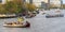 Party boats on river Amstel with people celebrating King\\\'s Day (Koningsdag in dutch)