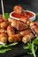 Party finger food pigs in blankets on toothpicks with ketchup sauce and wild rocket leaves