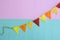 Party flags hanging on blue and pink background.