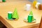 Party hats, paper plates, masks and green cups laying on the table ready for a kids birthday party, two sets, objects, closeup