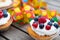 Party- muffins with fruits on wooden ground