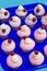 Party muffins with pink icing, whipped cream and cherry