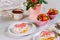 Party table with heart shaped donuts, strawberry and tea