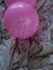 Party time pink baloon on a bed