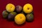 Pasiflora fruits and large yellow plums on red cloth napkin background, selective focus