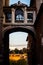 Passage to the ruins under an old footbridge between two typical building in Rome