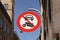 The passage of vehicles and motorcycles is prohibited. Round red and white traffic sign in a city with blue sky