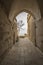 Passageway between stone buildings, old stone arch and in the background