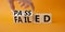 Passed and Failed symbol. Businessman hand turnes wooden cubes and changes word Failed to Passed. Beautiful orange background.