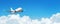 Passenger aircraft cloudscape with white airplane is flying in the daytime sky cumulus clouds, panorama view.