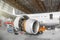 Passenger aircraft on maintenance of engine and fuselage repair in airport hangar. View airplane engine.