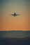 Passenger aircraft short after take off in evening lights. Airplane above airport runway at sunset. Dark, soft, dreamy colors