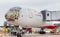 Passenger airplane Boeing 777-300 of Rossiya Airlines just landed, cargo is unloaded from the aircraft. Fuselage is painted as a f