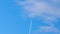 Passenger airplane at cruising altitude with contrail. Beautiful blue sky and white clouds.