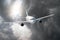 Passenger airplane flies through the turbulence zone through the lightning of storm clouds in bad weather.