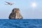 Passenger airplane flying above small limestone island in tropical andaman sea with sunlight.