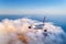 Passenger airplane flying over clouds at sunset