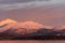 Passenger airplane flying over snow covered mountains on the norwegian coast in golden afternoon light