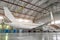 Passenger airplane in the hangar, enclosed engines and gangway at the entrance to the aircraft.