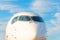 Passenger airplane nose cockpit in blue clouds evening sky