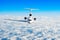Passenger airplane with three engines on the tail flying at flight level high in the sky above the clouds and blue sky. View direc