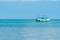 Passenger boat drifts over crystal clear water near the shore line of koh kood Island, Thailand