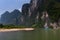 Passenger boat with tourists cruising in the Li River with the tall limestone peaks in the background near Yangshuo in China