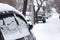 Passenger car with snowflakes at snowy overcast weather, side door with snow close up, urban landscape at cold snowfall