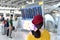 Passenger checking flight status at airport information display, Asian traveler looking at departure and arrival board.