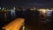 Passenger cruise ship sailing down of river at night party time along metropolis