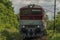 Passenger diesel red big train near Kysak station in summer hot morning