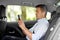 Passenger with earphones and cellphone in taxi car