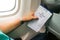 Passenger holding air sickness vomit bag in airplane