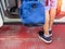 Passenger holding carry-on blue bag walking into airplane door