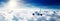 Passenger jet airplane flying through the clouds in the sky on a clear day. Travel background and wide aerial banner