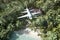 passenger light plane flies low over jungle and tropical beach