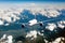 The passenger plane flies high above the clouds and earth. Front view of airplane