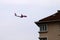 A passenger plane flies over the roof of a residential building