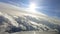 Passenger plane flies over white clouds.