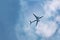 Passenger plane flies in sky, gaining height, bottom view.