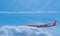 Passenger plane White red stripes flying in the sky on a bright blue day, white clouds in the daytime. To view, see the top of the