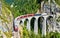 Passenger train crossing the Landwasser Viaduct in Switzerland