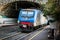 Passenger train driving out from tunnel near Riomaggiore town, Cinque Terre, Italy