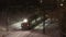 Passenger train goes on railbridge way under at night during snowfall