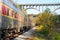 Passenger train under arched bridge