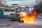Passenger transport passes near burning car