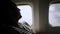 Passenger traveler looking at window in airplane, travel by flight, man tourist sitting in air plane.