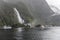 Passenger vessels and kayak flotilla in fjord at Bowen falls,  Milford Sound, New Zealand