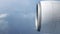 Passenger view through the window of a jet plane showing sky, clouds, engine.