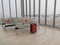 Passenger waiting area in transportation terminal keeping seat apart with the red luggage.